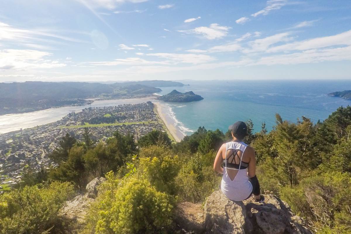 girl sitting on top of mount pauanui summit