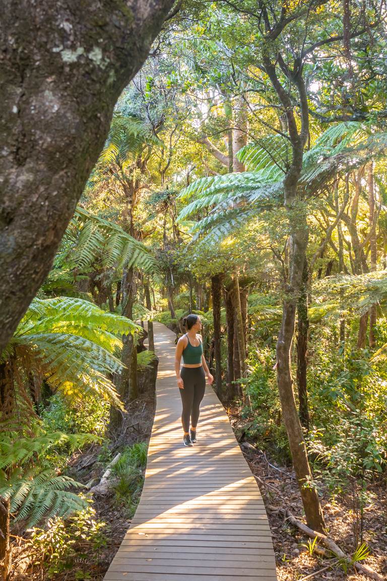 girl walking through Omanawanui bush in Whatipū