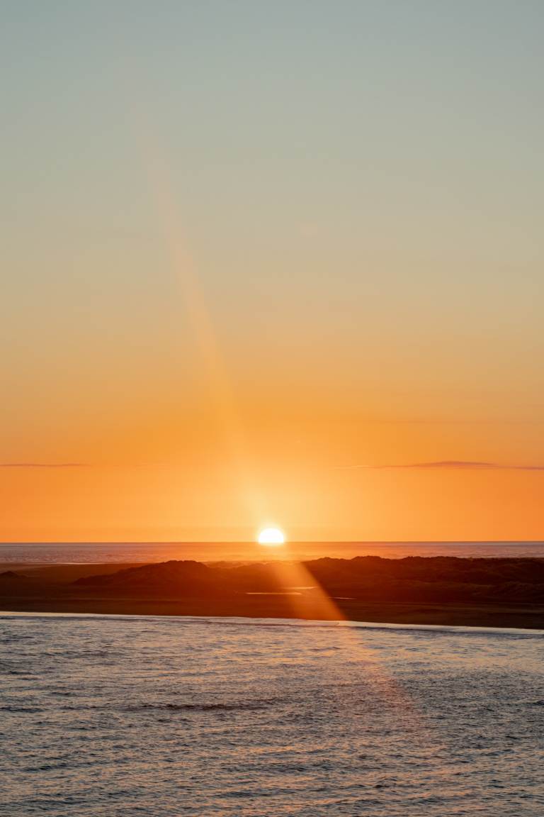 sun setting at Whatipū Beach