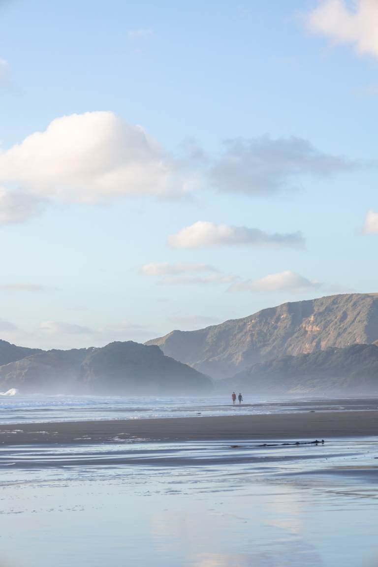 couple walking Bethells/Te Henga beach