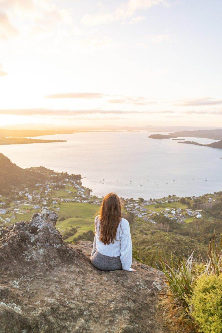 girl sitting at the top of mount manaia in northland hikes