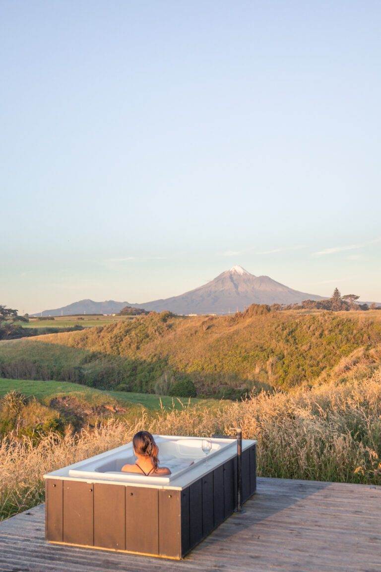 girl sitting in spa bath at airbnb overlooking mount taranaki