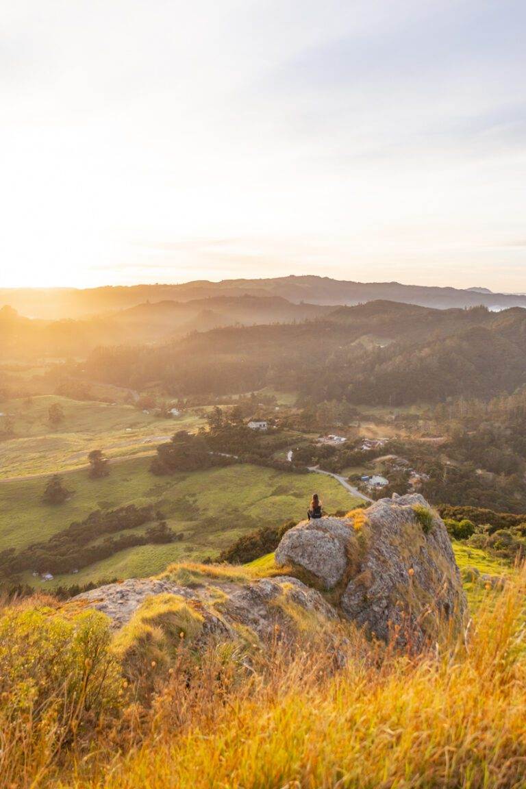 girl sitting at the edge of st pauls rock in northland