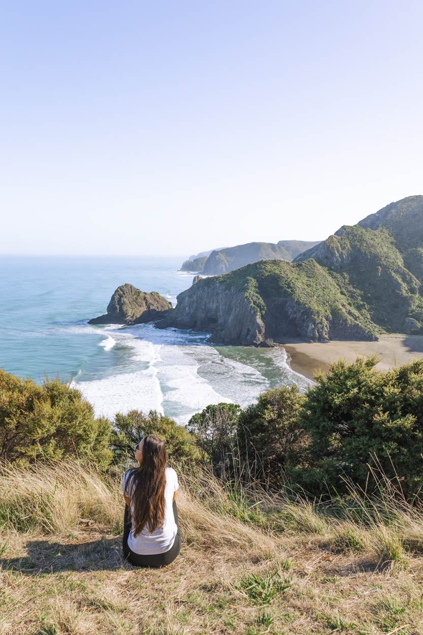 what is it like to live in Auckland girl sitting looking over coastline