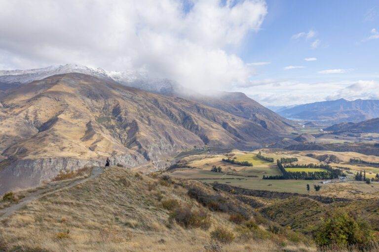 woman looking out from crown range summit during autumn