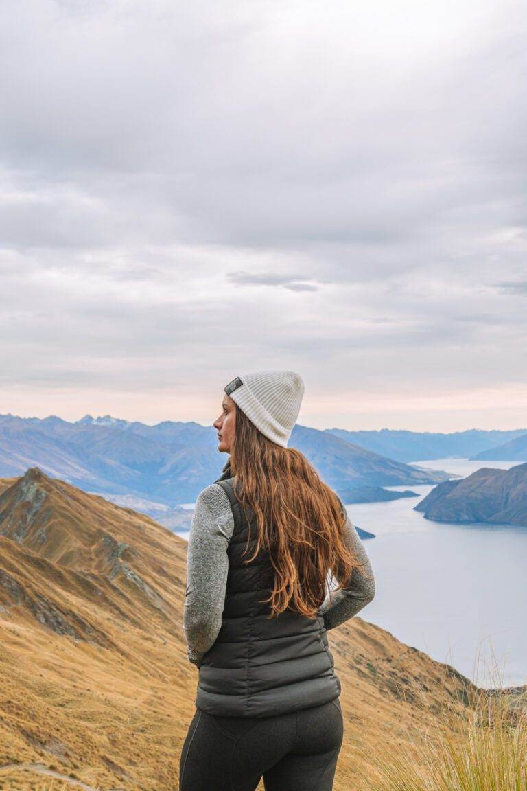 woman standing on roys peak hike in new zealand