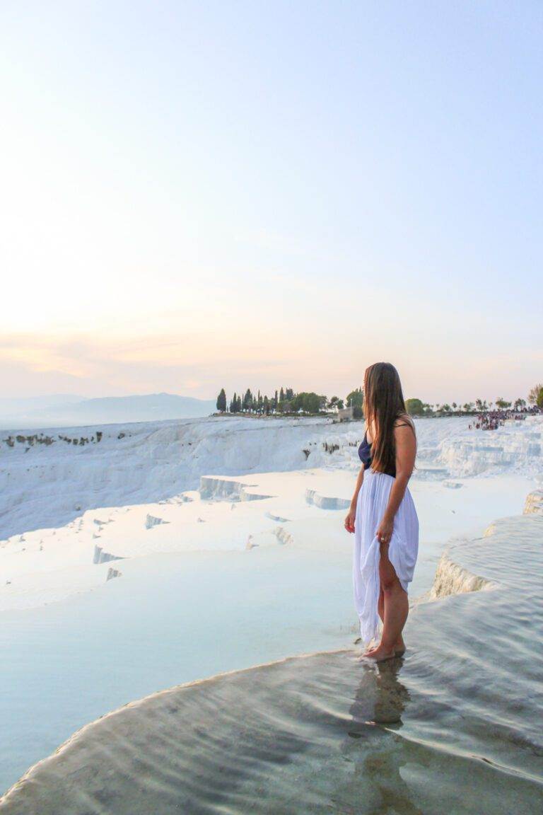 girl standing looking over cotton castle terraces at sunset