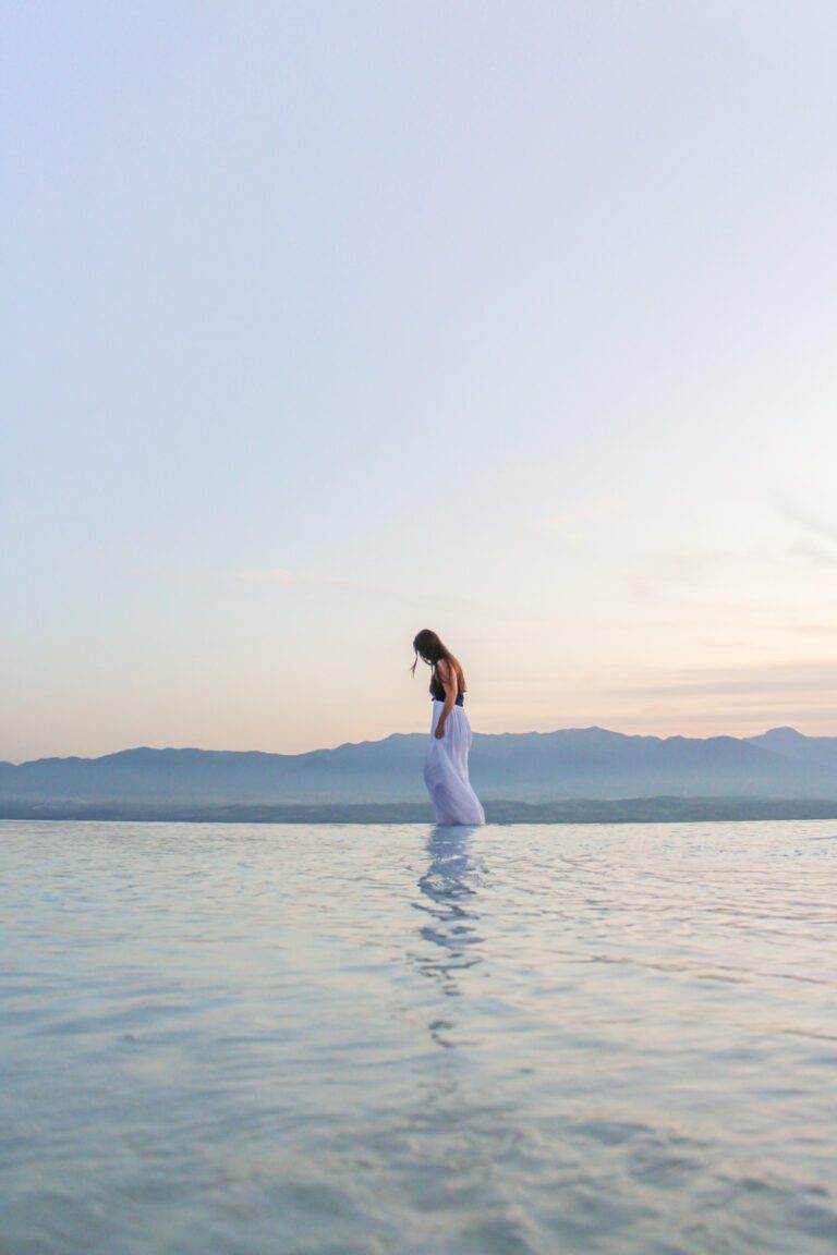 girl walking along edge of cotton castle terraces in pamukkale