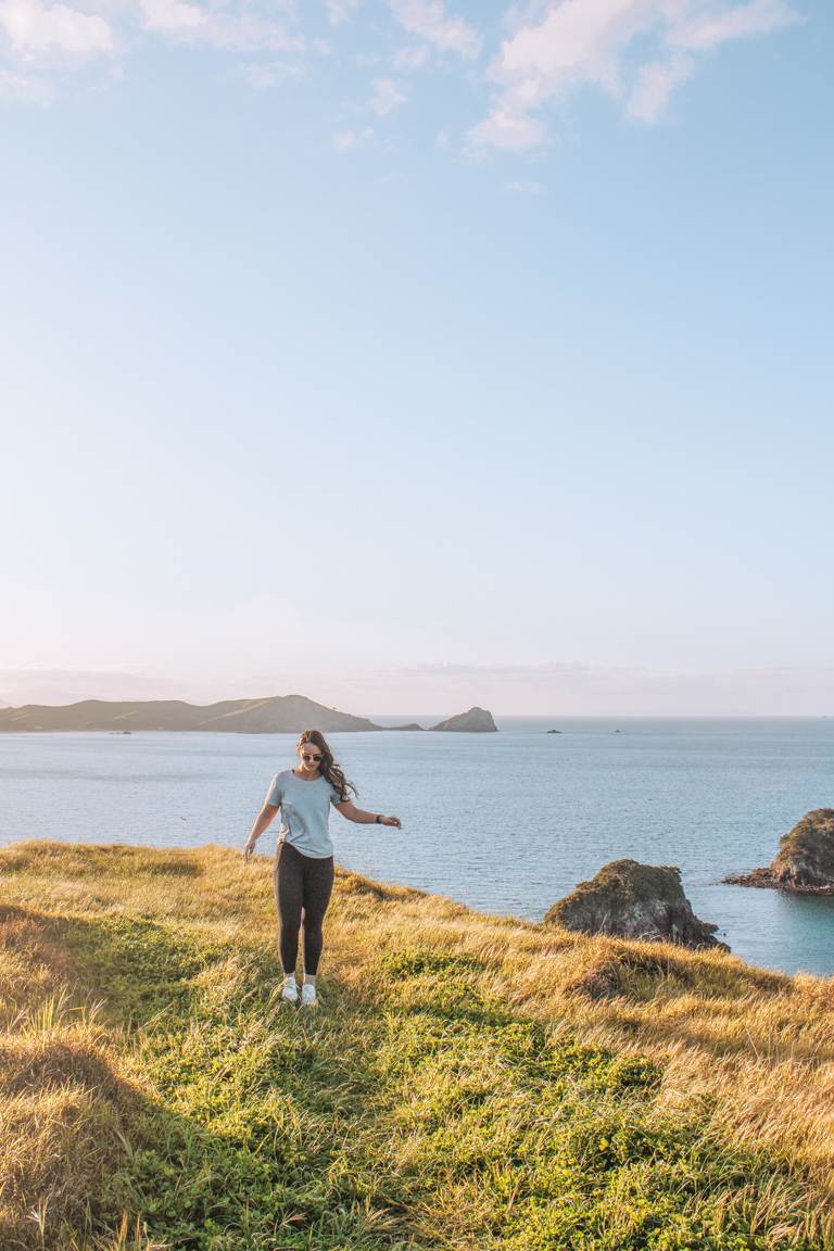 Girl walking along Opito Bay Pā headland