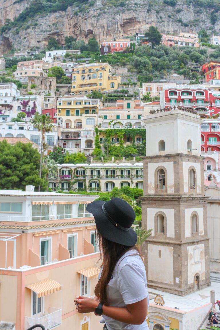 girl standing in front of positano homes and cliffside