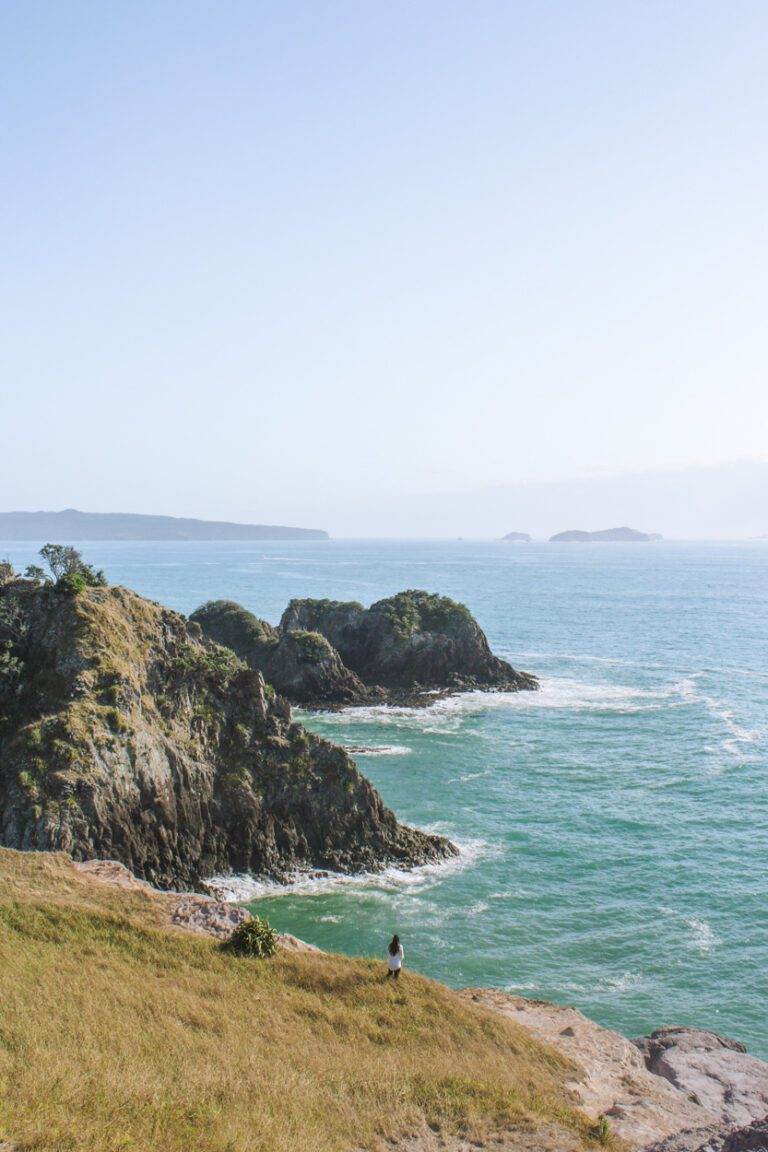 woman looking out over crayfish bay during summer in new zealand