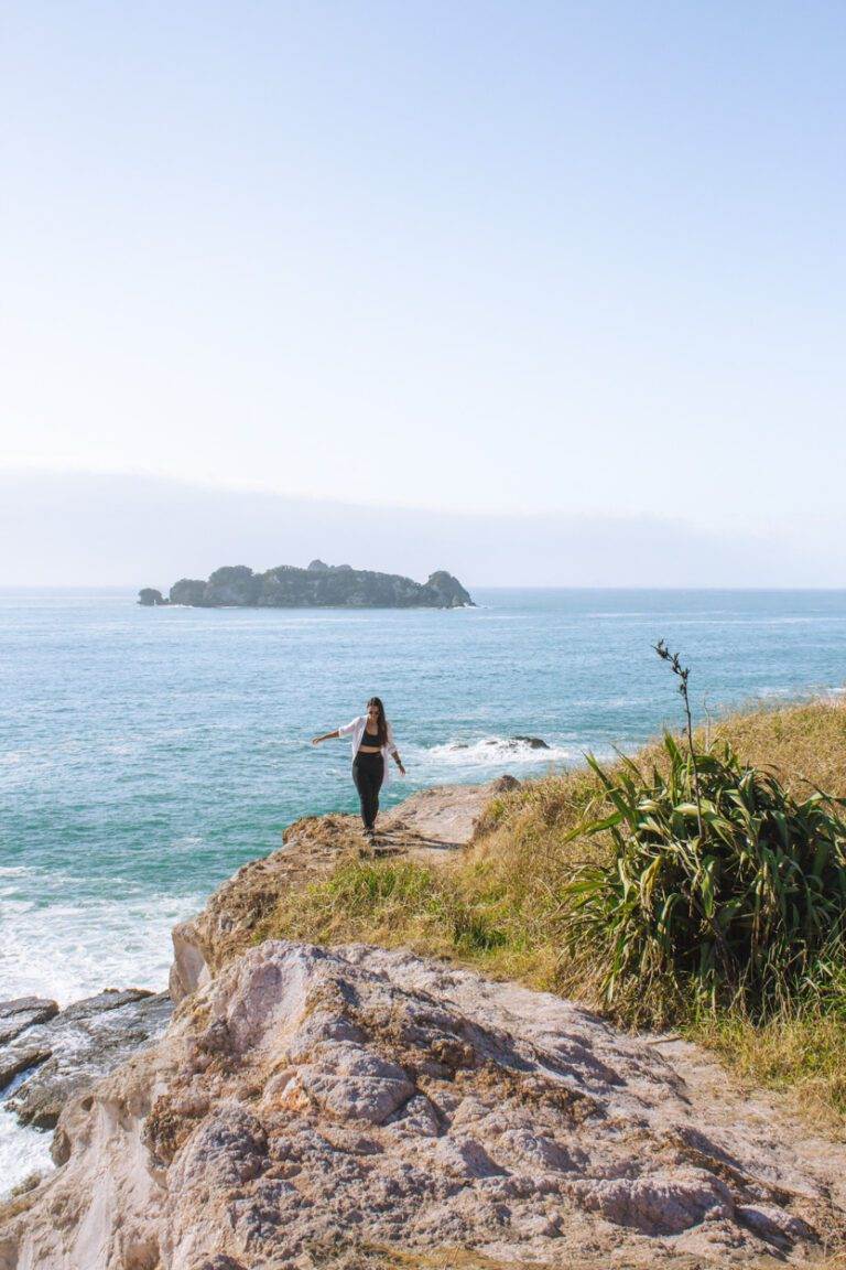 woman walking on rocks at crayfish bay coromandel destinations