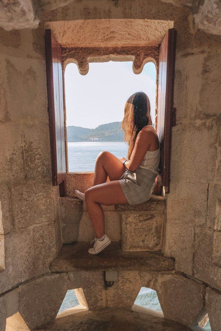 girl looking through window of belem tower