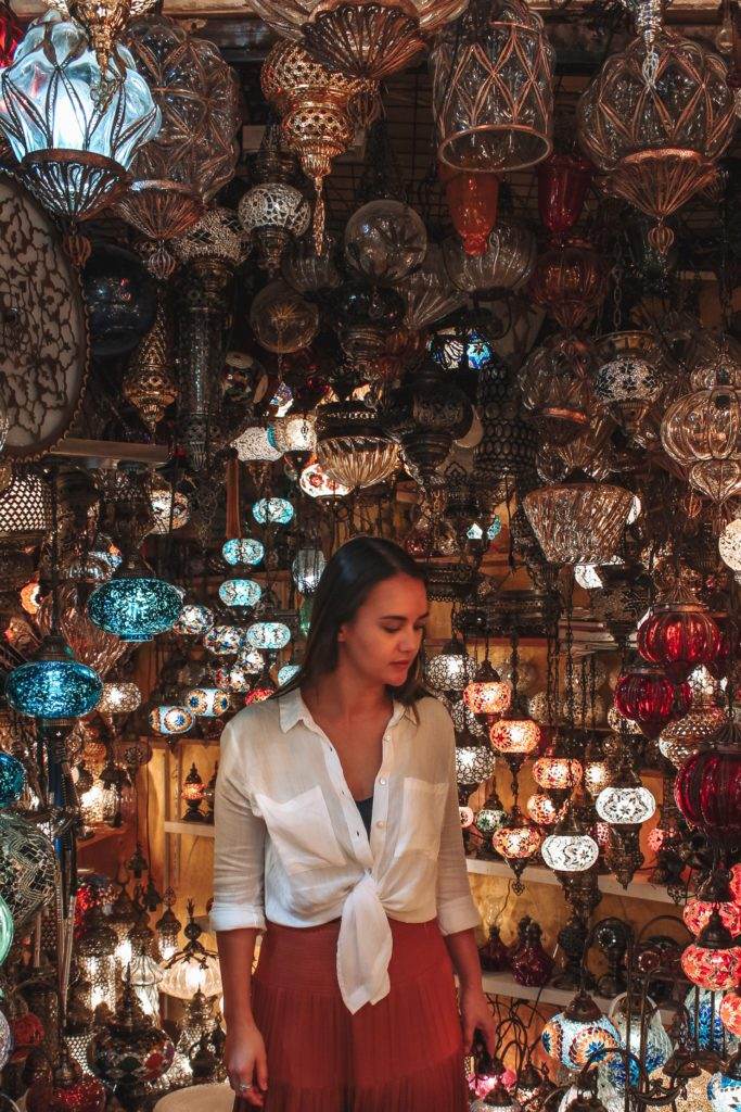 girl standing amongst lanterns in istanbul grand bazaar