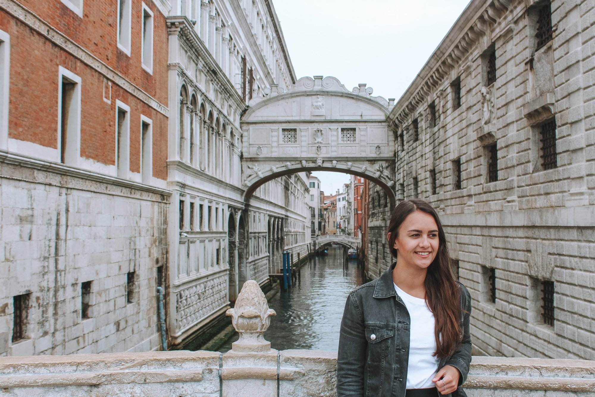 girl standing in front of the bridge of sighs venice